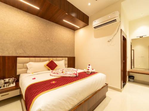 a bedroom with a large bed and a air conditioner at Hotel Elite inn in Thanjāvūr