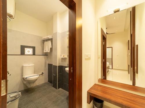 a bathroom with a toilet and a sink and a mirror at Hotel Elite inn in Thanjāvūr