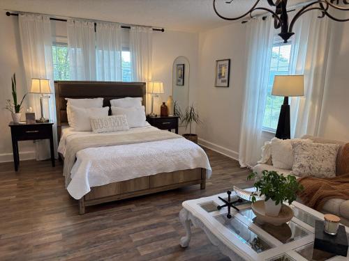 a bedroom with a bed and a couch and a table at Tranquil Suite Studio in Wilson
