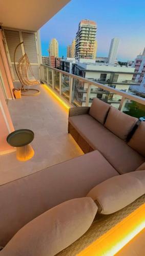 a couch on a balcony with a view of a city at GM Premium Portimão in Portimão