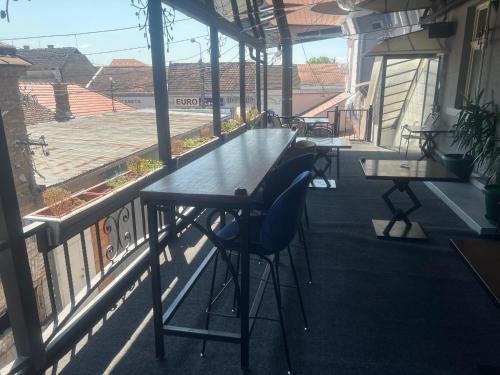 a bar with a table and a blue chair on a balcony at Tabacco in Obrenovac
