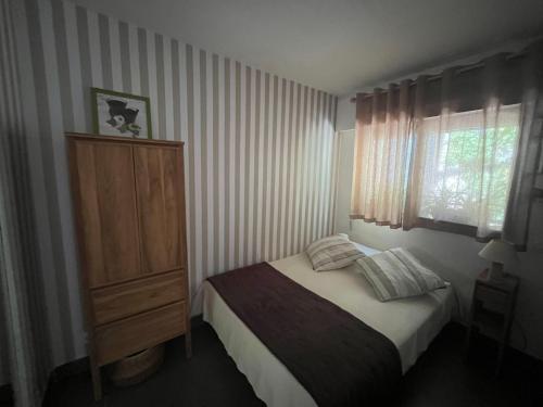 a bedroom with a bed and a dresser and a window at Lou soulèu in Cassis