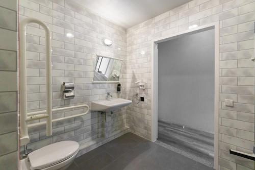 a bathroom with a toilet and a sink at a&o Köln Neumarkt in Cologne