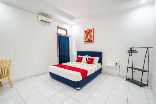 a bedroom with a bed and a chair in it at RedDoorz Plus near Universitas Maranatha Bandung 2 in Bandung