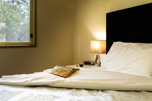 a bed with a book and a lamp on it at Watervale Retreat in Watervale
