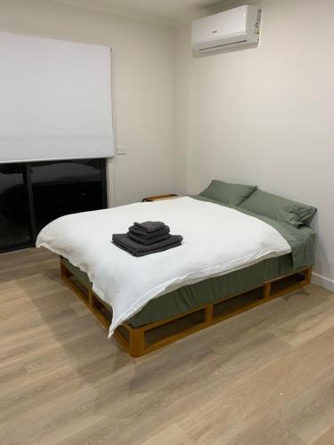 a bedroom with a bed with white sheets and a fan at Seymour Studios in Seymour