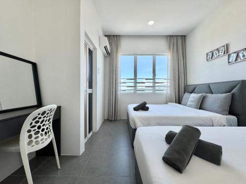 a hotel room with two beds and a television at Langkawi Simfoni Beliza Apartment with Sky Pool by Zervin in Kuah