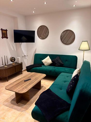 a living room with a green couch and a coffee table at Ela´s Alstadtliebe in Wertheim