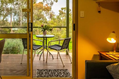 a door leading to a deck with a table and chairs at Watervale Retreat in Watervale