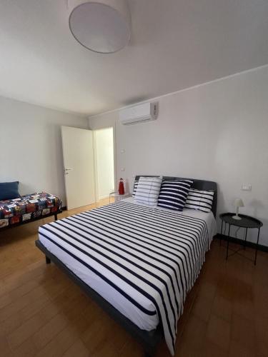a bedroom with a large bed with black and white stripes at Casa Ficcanaso in Caorle