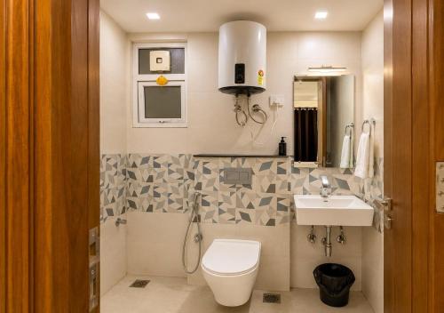 a bathroom with a toilet and a sink at Lime Tree Hotel Golf Course Extension Nearby Grand Hyatt Gurgaon in Gurgaon