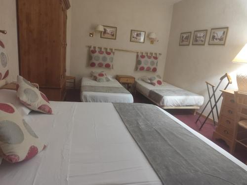 a room with two beds and a dresser and a room with two beds at Hôtel Saint Jean in Orange