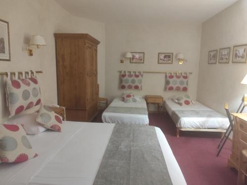 a bedroom with two beds and a dresser at Hôtel Saint Jean in Orange