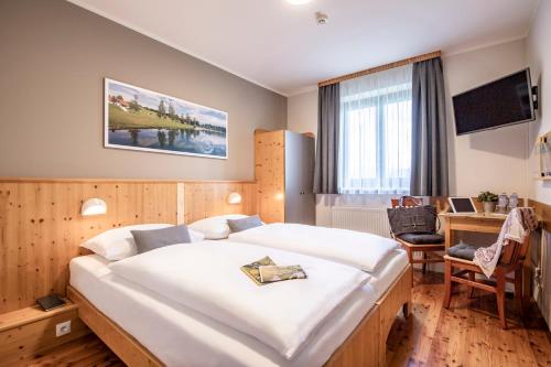 a bedroom with a large white bed and a desk at JUFA Hotel Maria Lankowitz am See in Maria Lankowitz