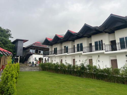 a row of white buildings with black roofs at Aabuu Babuu Resort & Banquet in Kurseong