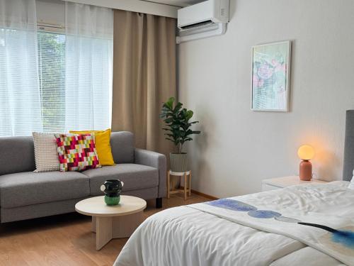 ein Wohnzimmer mit einem Bett und einer Couch in der Unterkunft Mon Koti in Turku