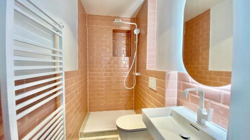 a bathroom with pink tiles and a sink at STACEY Alster in Hamburg
