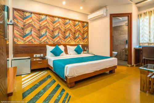 a bedroom with a bed and a large painting on the wall at Uddhav Vilas A Family Hotel in Udaipur