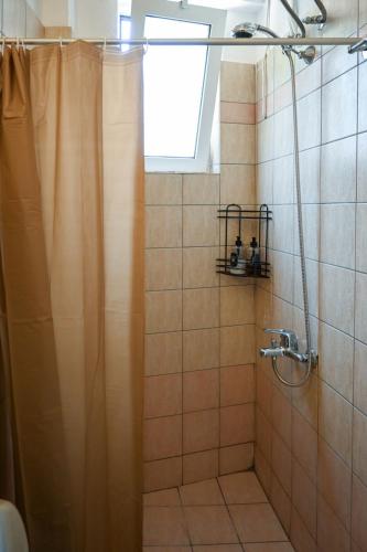 a bathroom with a shower with a shower curtain at Sunset Stories Apartments in Konitsa