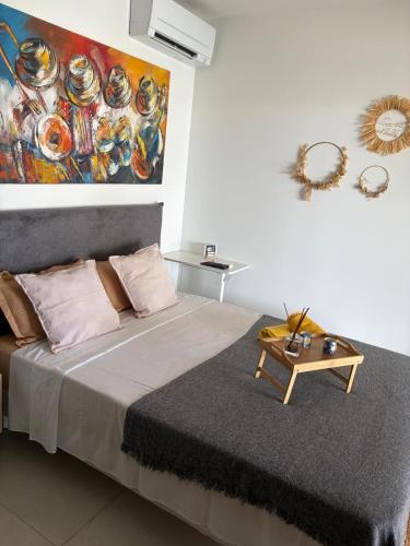 a bedroom with a bed with a painting on the wall at Studio neuf avec acces piscine in Valergues
