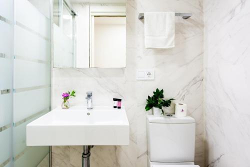 a white bathroom with a sink and a toilet at Luxurious Two Bed in Torrox