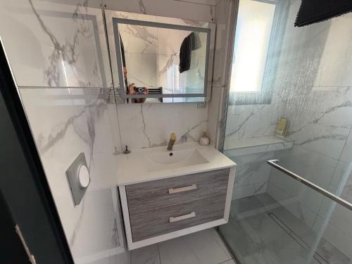 a white bathroom with a sink and a shower at appartement Sorgues in Sorgues