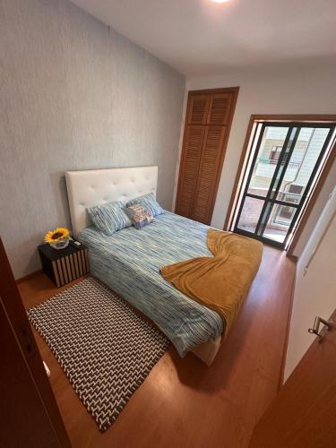 a bedroom with a large bed with a window at RAFURADOURO in Ovar