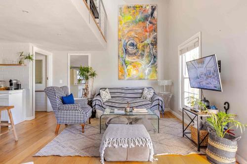 a living room with a couch and a painting on the wall at Magnolia Cottage in Cape Town