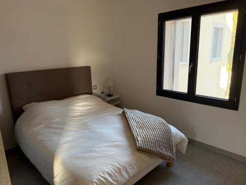 a white bed in a bedroom with a window at appartement Sorgues in Sorgues