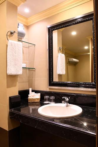 a bathroom with a sink and a mirror at Herald Suites Polaris in Manila