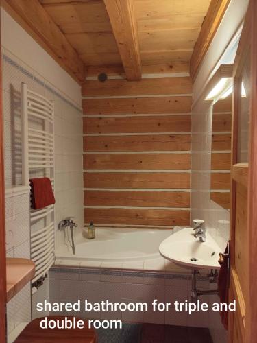 a bathroom with a tub and a sink at Roubenka Skalnička in Adršpach