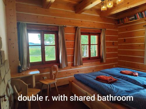 a bedroom with a bed in a log cabin at Roubenka Skalnička in Adršpach