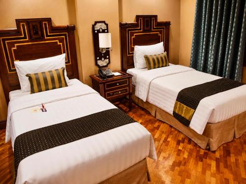 a hotel room with two beds and a telephone at Herald Suites Polaris in Manila