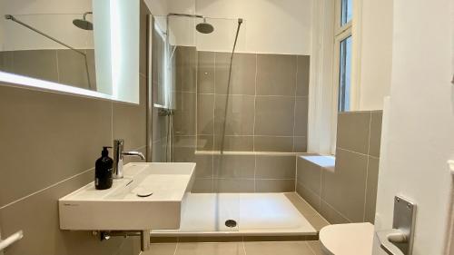 a bathroom with a white sink and a shower at STACEY Downtown in Hamburg