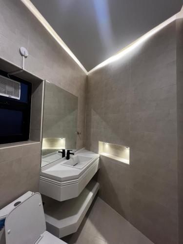 a bathroom with a white sink and a toilet at هابينيس شاليه in Salalah