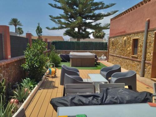 a patio with chairs and a table and a tree at Chalet en Costacabana in Costacabana