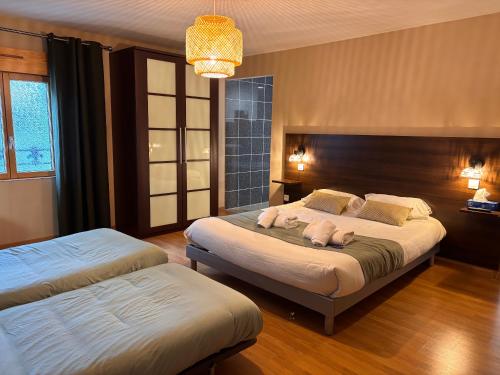 a bedroom with two beds and a chandelier at La Tour Des Lys in Maubeuge