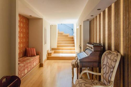a living room with a piano and a staircase at Civitas Suites Hotel in Rethymno Town