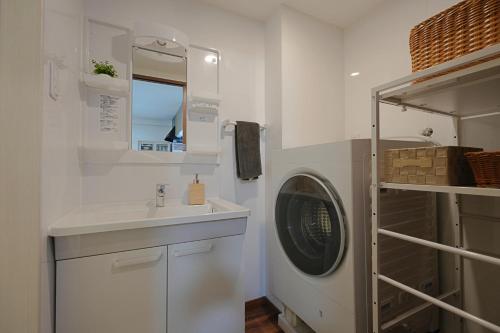 a bathroom with a washing machine and a sink at INA HOUSE Miyakojima 302 in Miyakojima