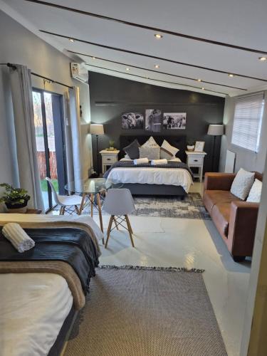 a large bedroom with a bed and a couch at Toekoms Inn in Aliwal North