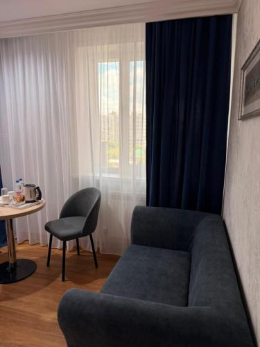 a living room with a couch and a chair and a table at King Hotel Astana in Astana