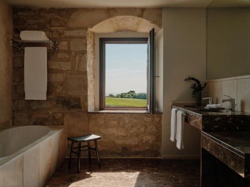ein Badezimmer mit Badewanne und Fenster in der Unterkunft Palacio de Luces, Small Luxury Hotels in Luces