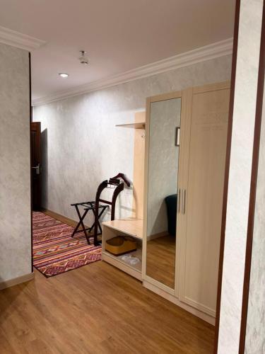 a room with a room with a mirror and a table at King Hotel Astana in Astana