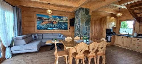 a living room with a table and a couch at Królowo Chatka Na Budzu in Czerwienne