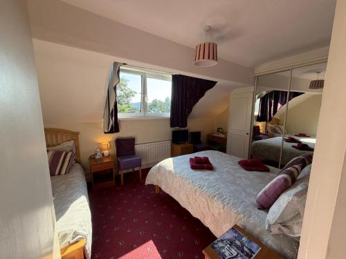 a bedroom with two beds and a mirror at Adam Place Guest House in Windermere