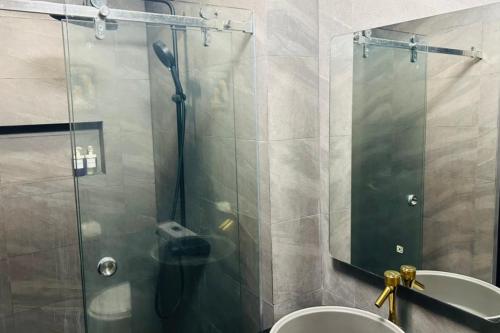 a bathroom with a shower and a sink and a mirror at Crosswinds Nature View Suite in Tagaytay
