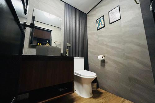 a bathroom with a white toilet and a mirror at Crosswinds Nature View Suite in Tagaytay
