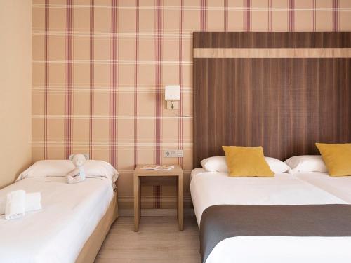 a hotel room with two beds and a table at Ona Diana Park in Estepona