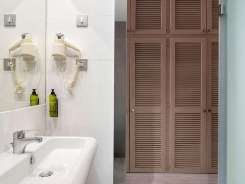 a bathroom with a sink and a wooden door at Ona Diana Park in Estepona