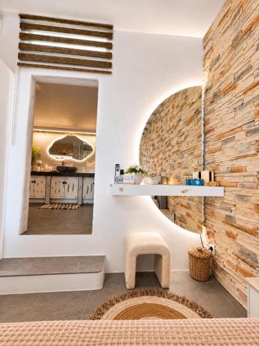 a room with a brick wall and a mirror at Miloa Klima View 'Syrma' in Klima